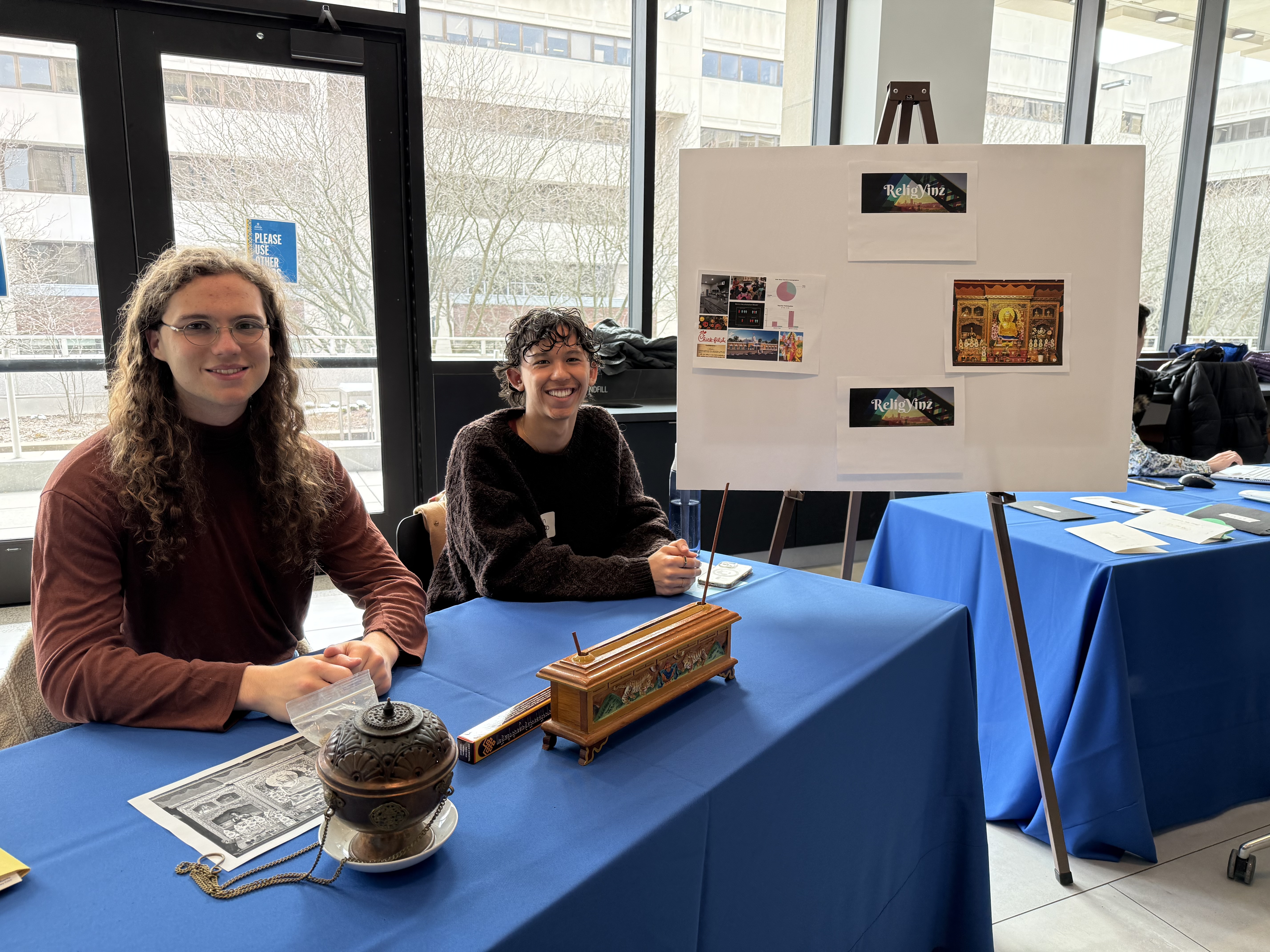 Students smiling with their ReligYinz presentation board